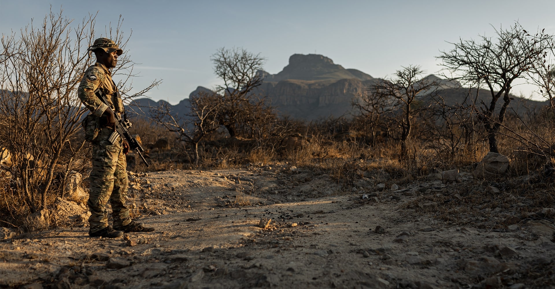 Park ranger observing the distant savanna at sunrise in Africa.