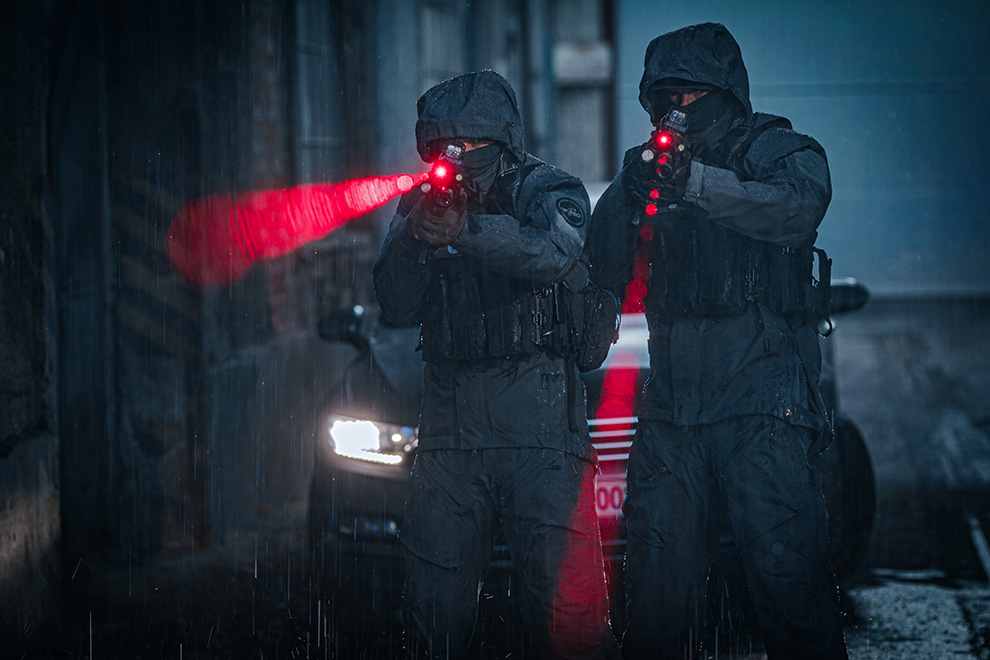 Two Law Enforcement personnel in the rain wearing UF PRO Monsoon XT Gen.2 Jackets