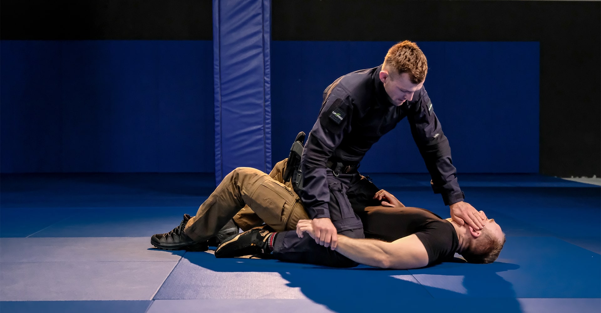 A BJJ instructor demonstrating head control by turning the opponent's head away.