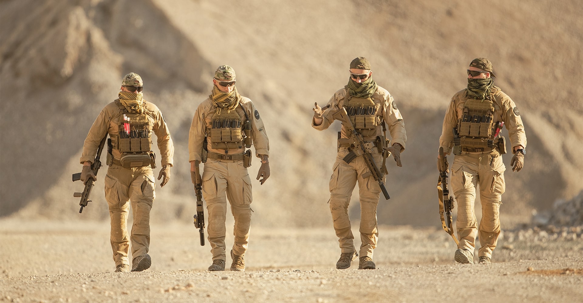 Tactical operators moving across a desert landscape after completing a high-intensity mission.