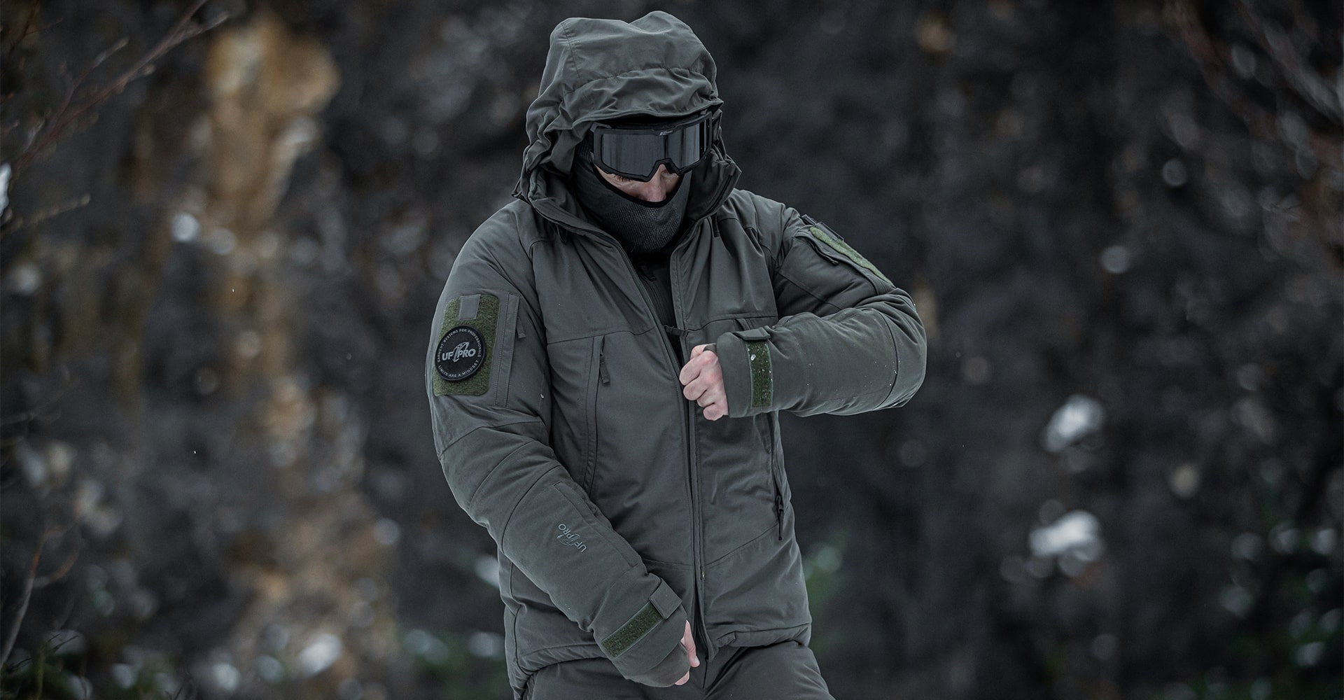 An operator zipping his winter tactical clothing. 