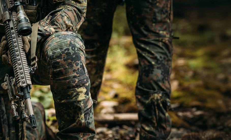 Two operators, partially visible from the waist down—one kneeling with a firearm pointed downward, the other standing behind. How to Maximize the Lifespan of Your Combat Pants