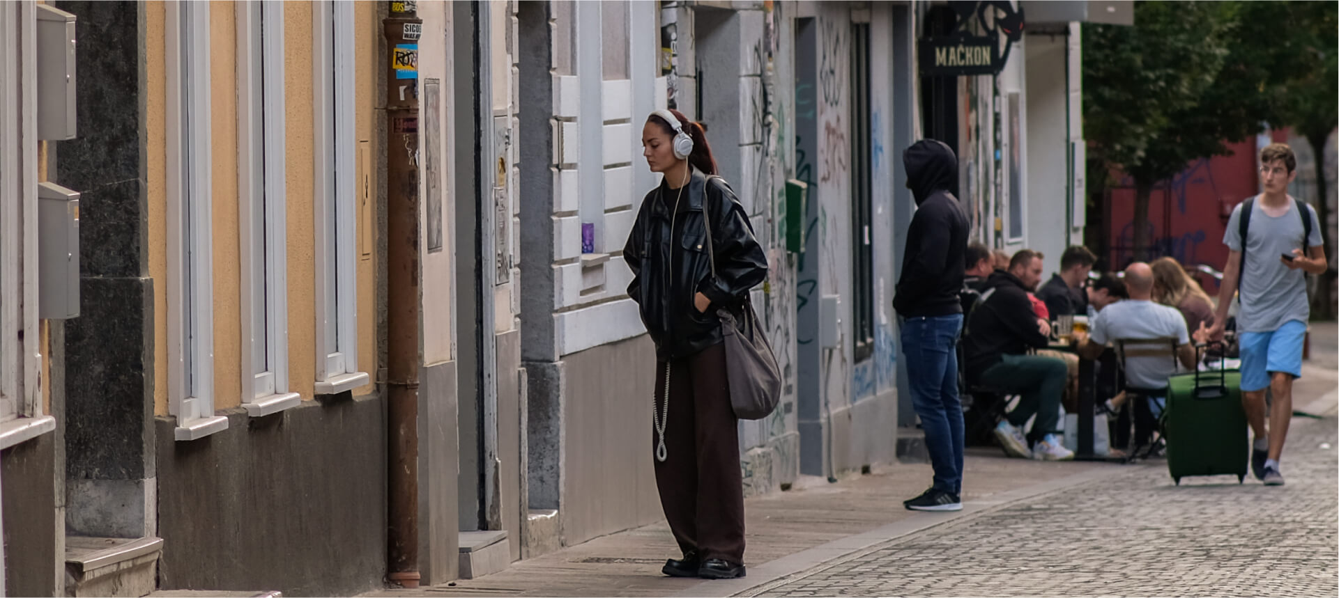 Individual walking confidently in an urban setting while observing his environment, demonstrating situational awareness.