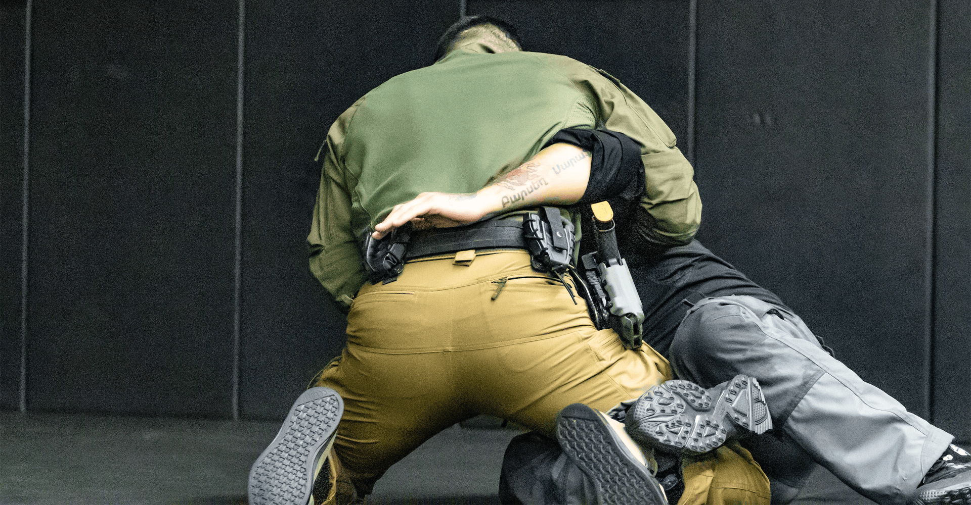 Two operators engaged on the ground, struggling for control of a firearm or knife in a close-combat scenario.