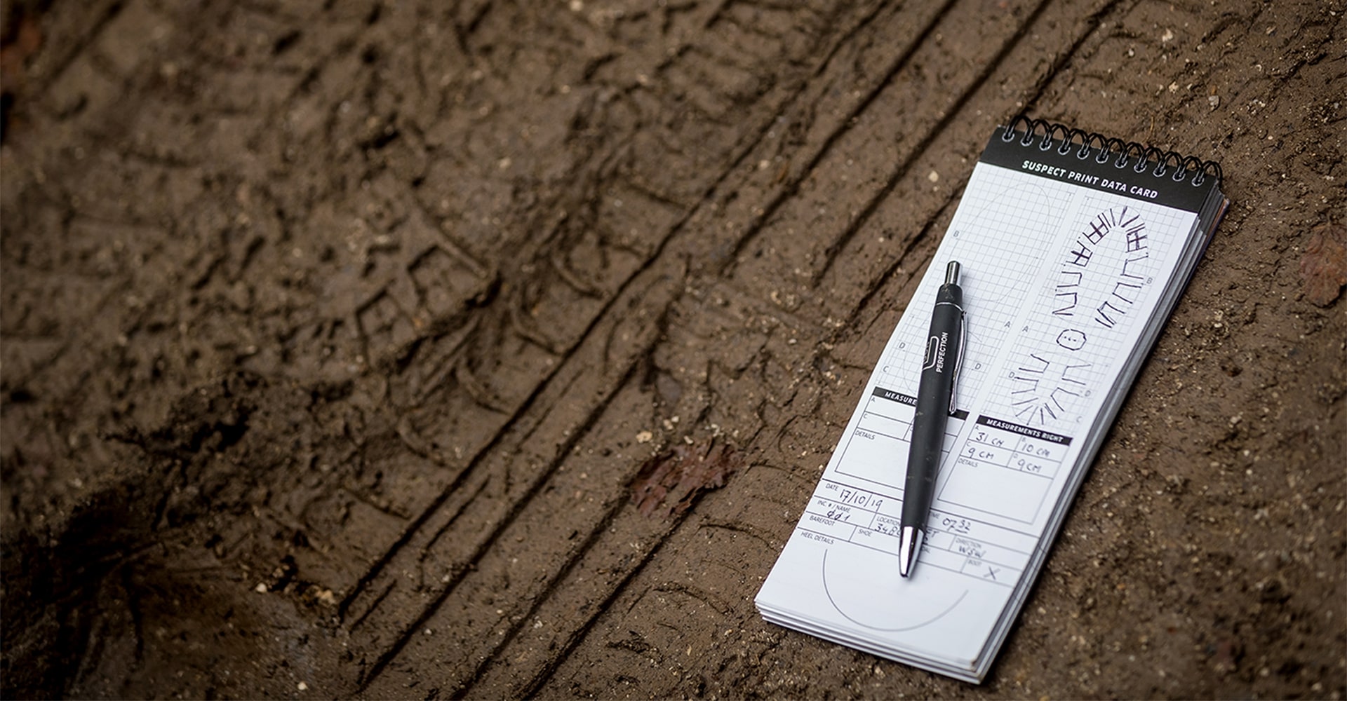 Extracting details from a single footprint on muddy terrain and recording it in a notepad.