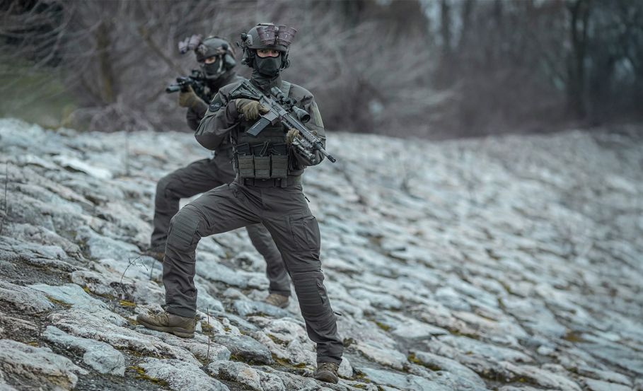 two operators in tactical gear with weapons in arms, pictured in rocky terain Myths About Tactical Clothing You Need to Stop Believing