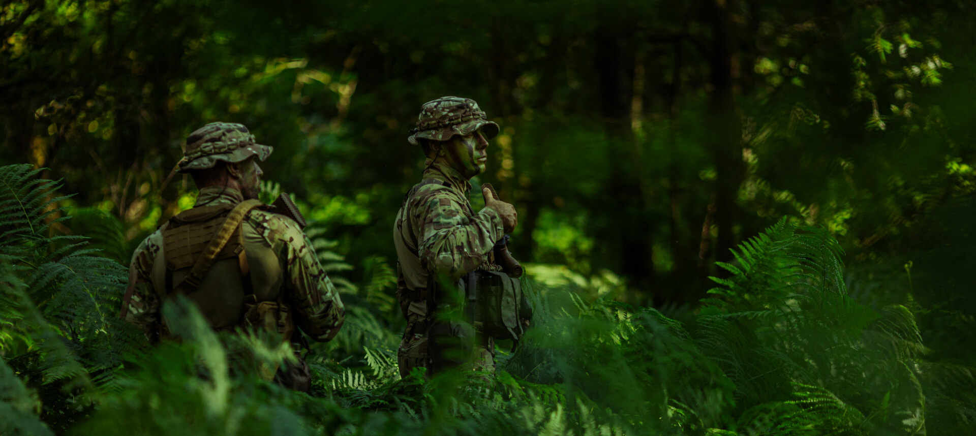 Thermal image of three figures emitting heat in bright tones, set against a cooler forest background.