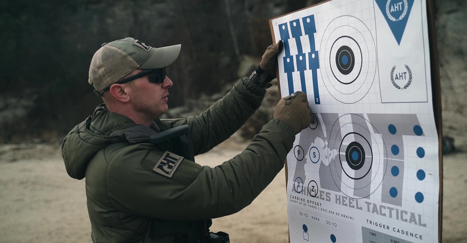 A sports shooter on an outdoor range examining a target.