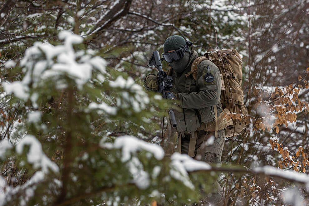 Tactical operator walking through a dense forest
