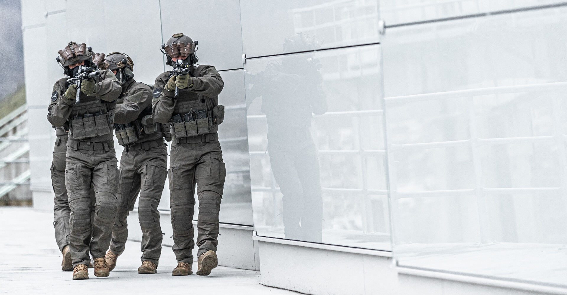 Four operators in close formation, advancing through an urban environment on a mission.