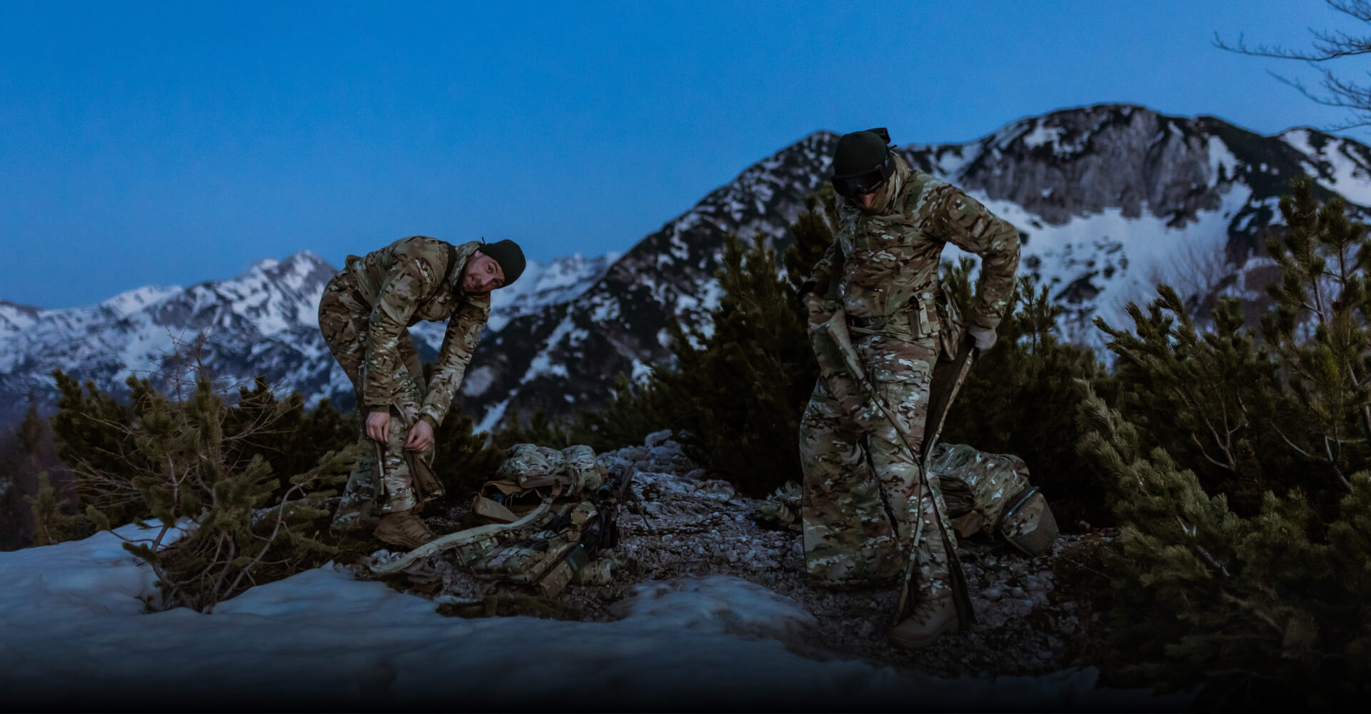 MISSION-SPECIFIC COLD WEATHER CLOTHING Soldiers are putting on an overall suit in the mountain in the winter.