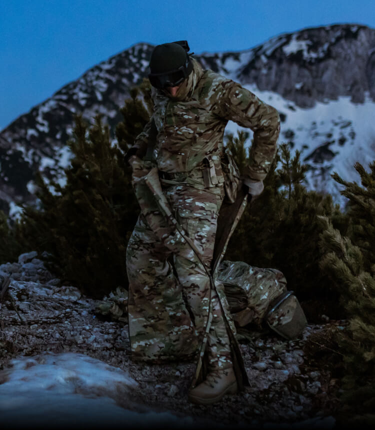 MISSION-SPECIFIC COLD WEATHER CLOTHING Soldiers are putting on an overall suit in the mountain in the winter.