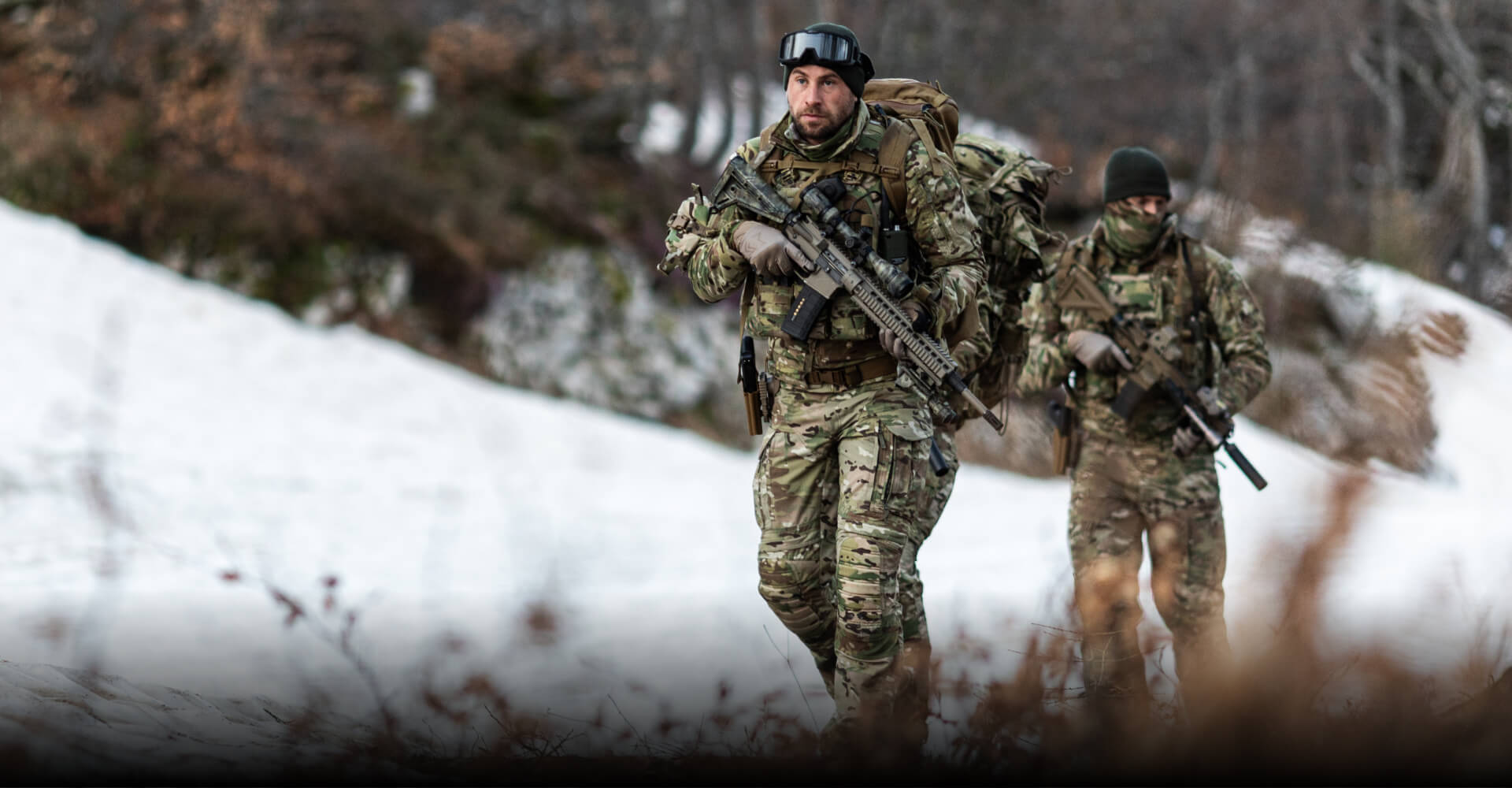 GEARING UP FOR ACTIVITY LEVELS  Alt text: Soldiers in MultiCam winter gear walking uphill in a snowy environment.
